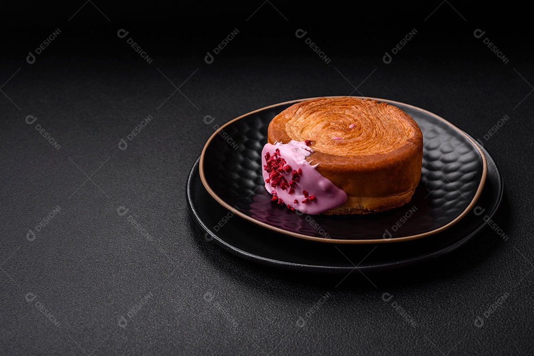 Croissant redondo de massa folhada com recheio de framboesa ou rolo de Nova Iorque sobre fundo escuro de concreto