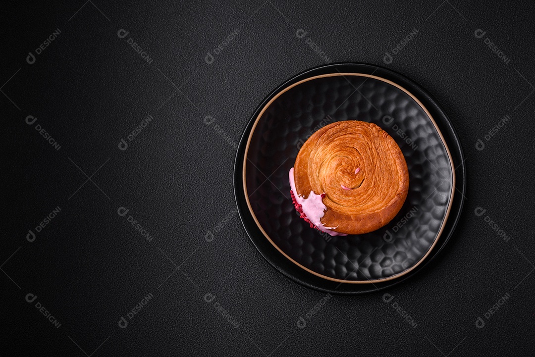 Croissant redondo de massa folhada com recheio de framboesa ou rolo de Nova Iorque sobre fundo escuro de concreto