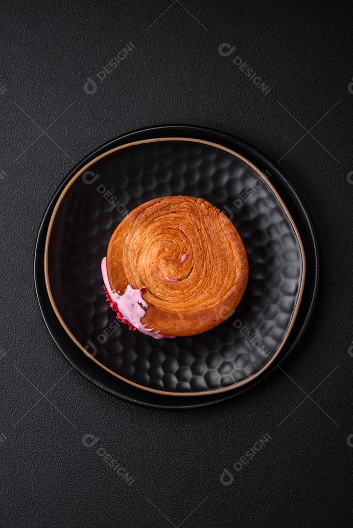 Croissant redondo de massa folhada com recheio de framboesa ou rolo de Nova Iorque sobre fundo escuro de concreto