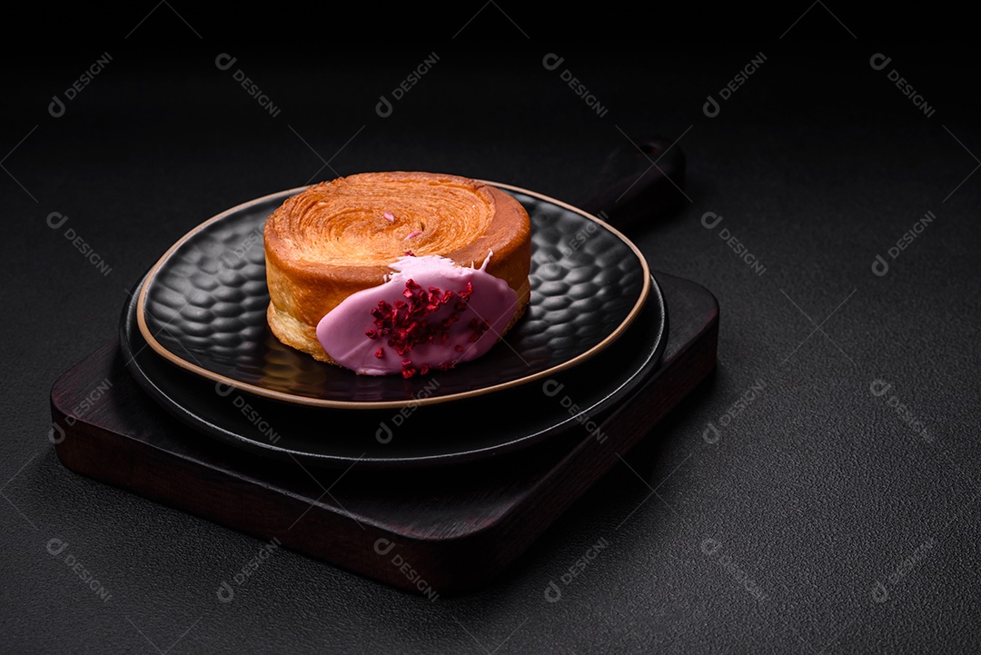 Croissant redondo de massa folhada com recheio de framboesa ou rolo de Nova Iorque sobre fundo escuro de concreto