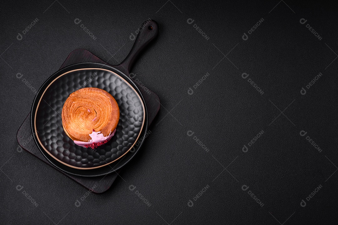 Croissant redondo de massa folhada com recheio de framboesa ou rolo de Nova Iorque sobre fundo escuro de concreto