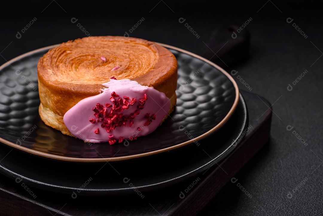 Croissant redondo de massa folhada com recheio de framboesa ou rolo de Nova Iorque sobre fundo escuro de concreto