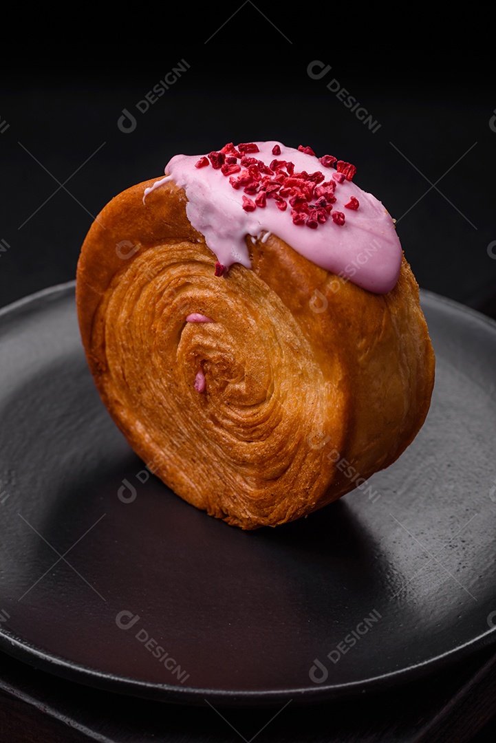 Croissant redondo de massa folhada com recheio de framboesa ou rolo de Nova Iorque sobre fundo escuro de concreto