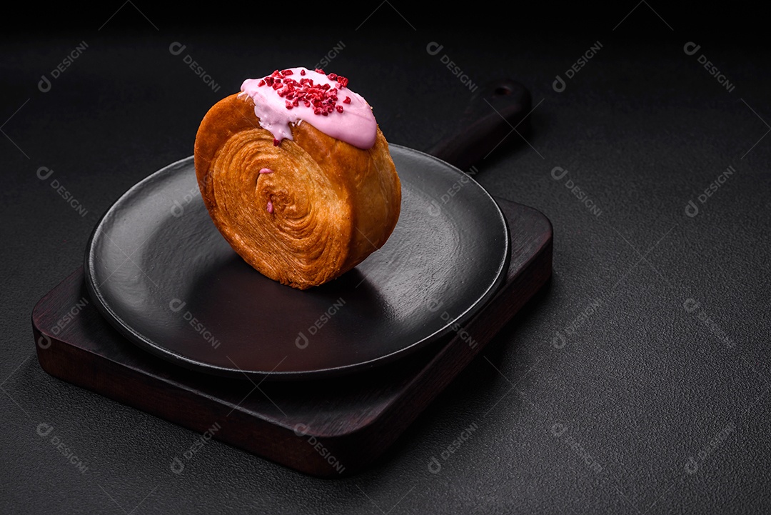 Croissant redondo de massa folhada com recheio de framboesa ou rolo de Nova Iorque sobre fundo escuro de concreto