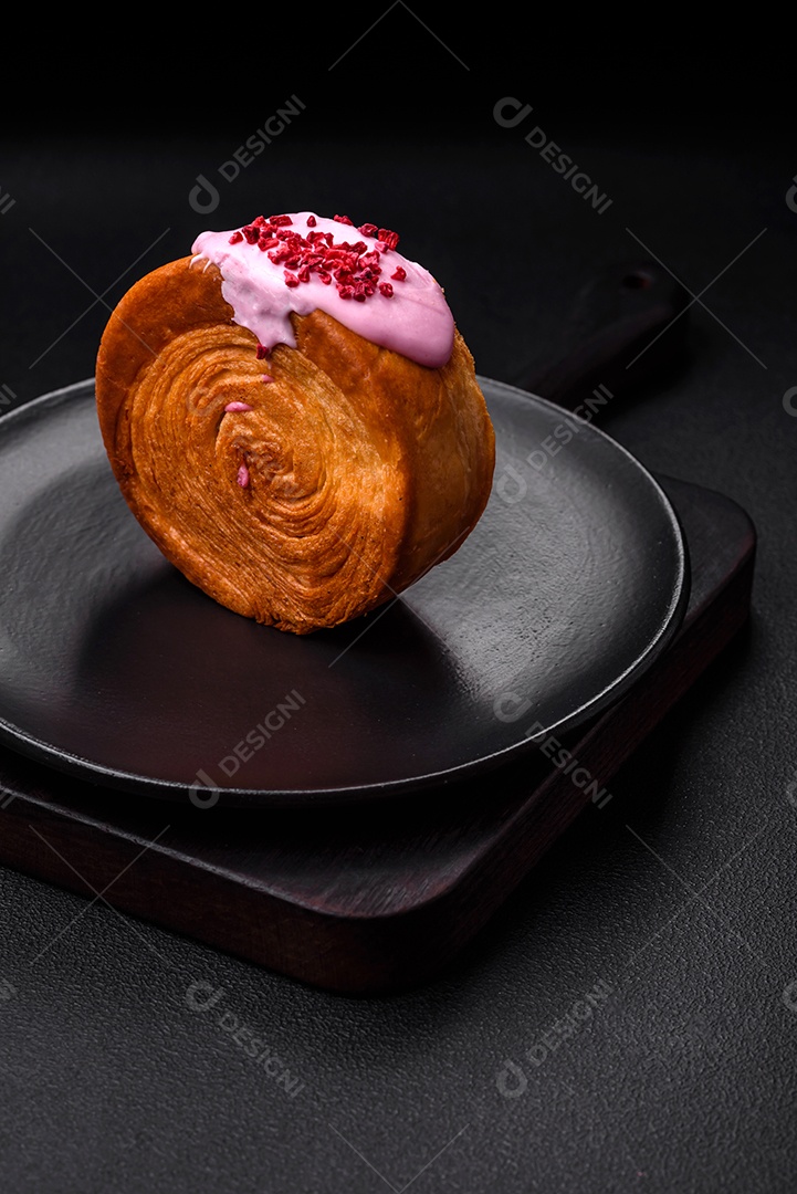 Croissant redondo de massa folhada com recheio de framboesa ou rolo de Nova Iorque sobre fundo escuro de concreto