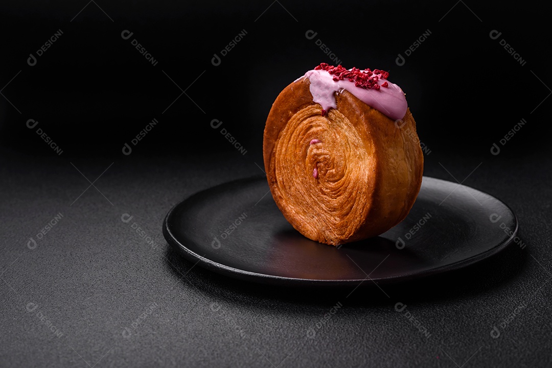 Croissant redondo de massa folhada com recheio de framboesa ou rolo de Nova Iorque sobre fundo escuro de concreto