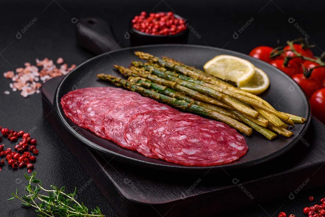 Delicioso café da manhã nutritivo composto por espargos, ovos mexidos, sal, especiarias e ervas sobre um fundo escuro de concreto