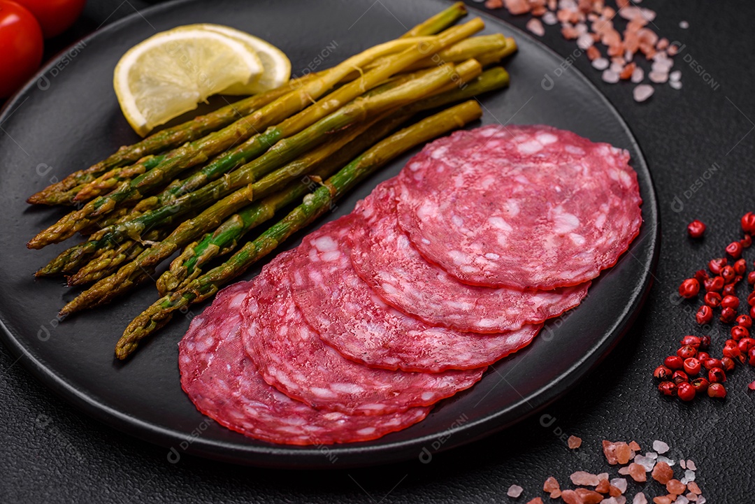 Delicioso café da manhã nutritivo composto por espargos, ovos mexidos, sal, especiarias e ervas sobre um fundo escuro de concreto