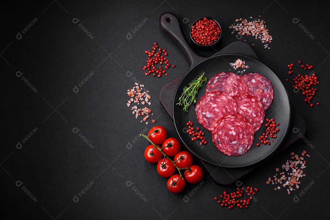 Delicioso café da manhã nutritivo composto por salsicha fatiada, espargos, sal, especiarias e ervas sobre um fundo escuro de concreto0