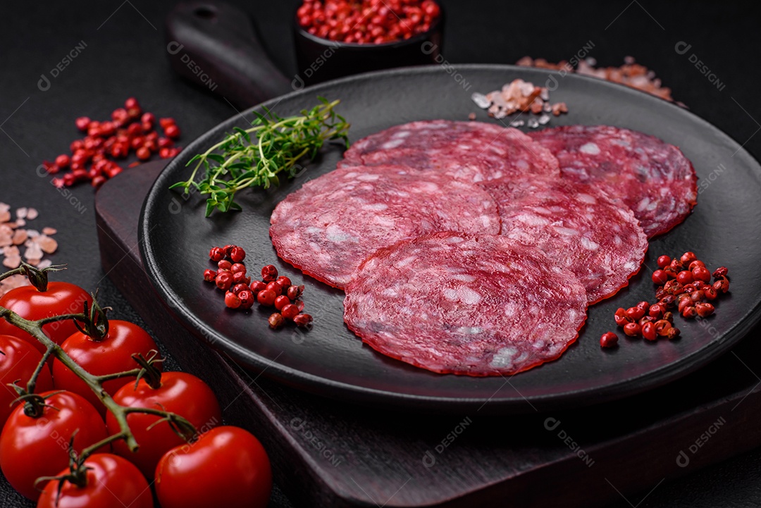 Delicioso café da manhã nutritivo composto por salsicha fatiada, espargos, sal, especiarias e ervas sobre um fundo escuro de concreto0