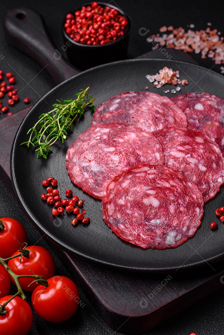 Delicioso café da manhã nutritivo composto por salsicha fatiada, espargos, sal, especiarias e ervas sobre um fundo escuro de concreto0