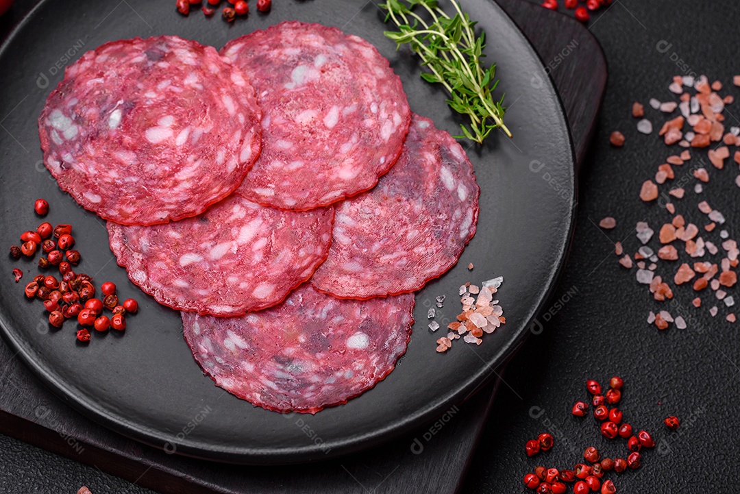 Delicioso café da manhã nutritivo composto por salsicha fatiada, espargos, sal, especiarias e ervas sobre um fundo escuro de concreto0