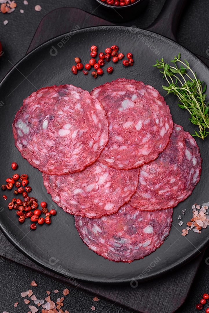 Delicioso café da manhã nutritivo composto por salsicha fatiada, espargos, sal, especiarias e ervas sobre um fundo escuro de concreto0