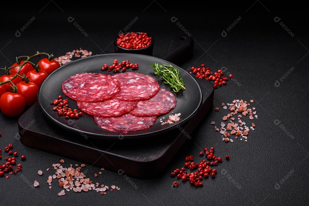 Delicioso café da manhã nutritivo composto por salsicha fatiada, espargos, sal, especiarias e ervas sobre um fundo escuro de concreto0