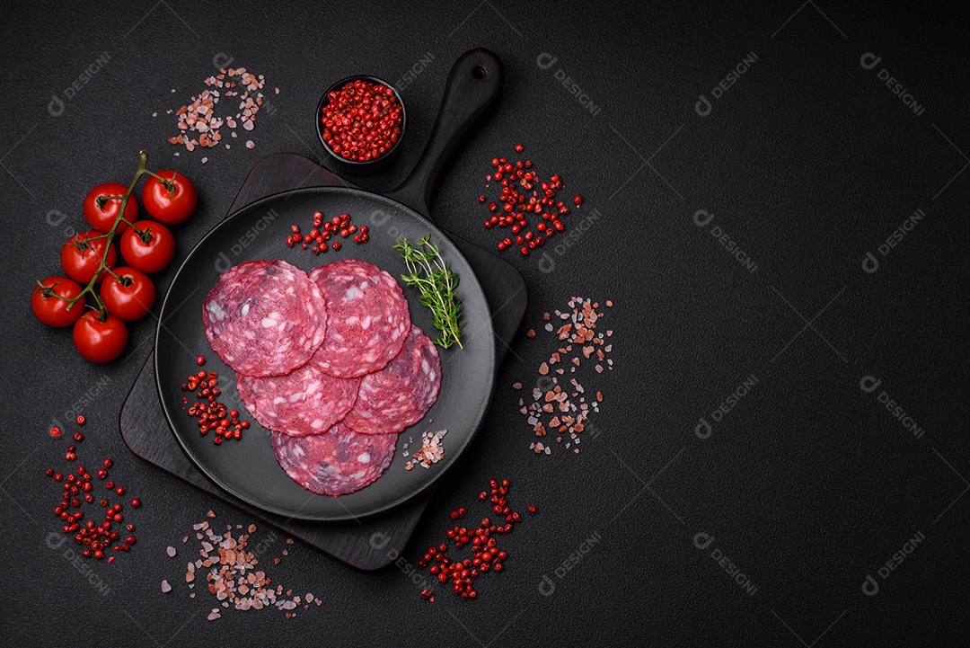 Delicioso café da manhã nutritivo composto por salsicha fatiada, espargos, sal, especiarias e ervas sobre um fundo escuro de concreto0