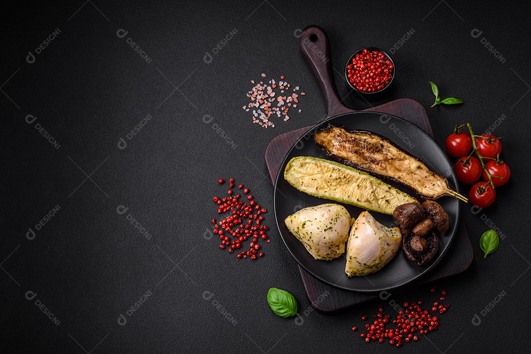 Deliciosos legumes grelhados, abobrinha, berinjela, pimentão e cogumelos com sal, especiarias e ervas sobre um fundo escuro de concreto