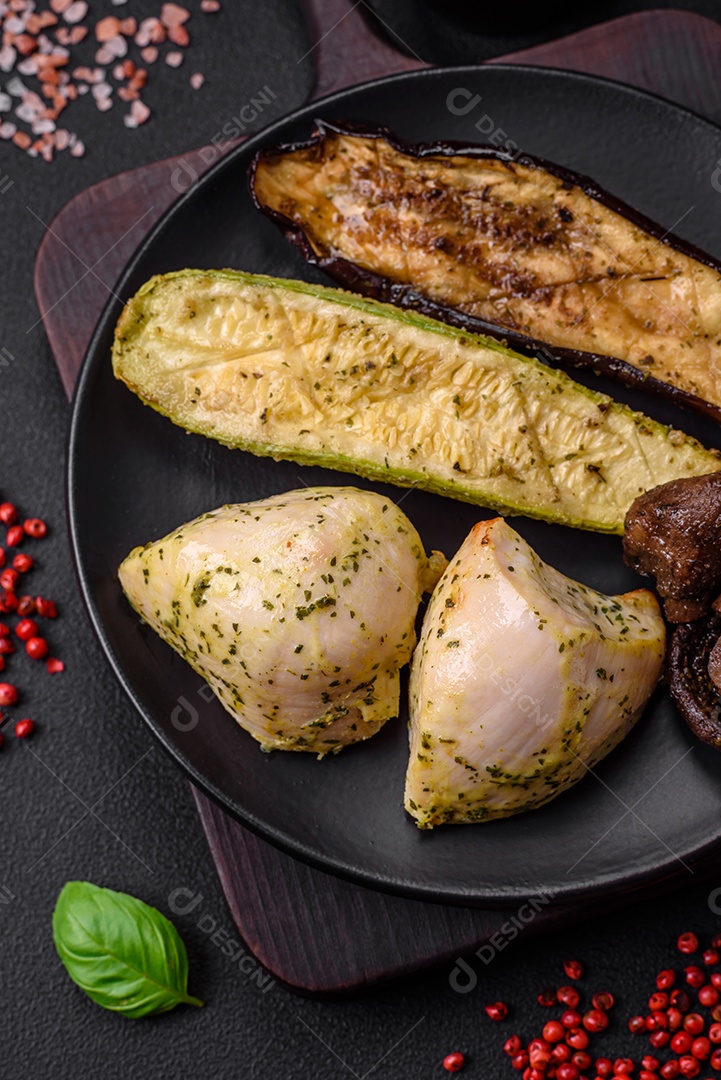 Deliciosos legumes grelhados, abobrinha, berinjela, pimentão e cogumelos com sal, especiarias e ervas sobre um fundo escuro de concreto