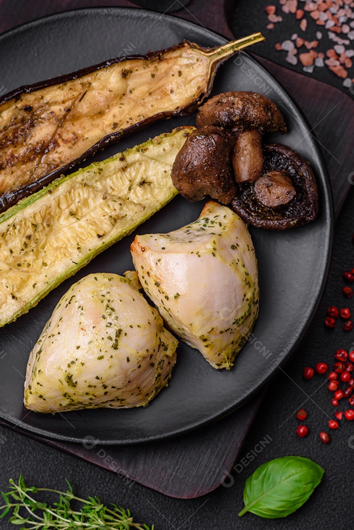 Deliciosos legumes grelhados, abobrinha, berinjela, pimentão e cogumelos com sal, especiarias e ervas sobre um fundo escuro de concreto