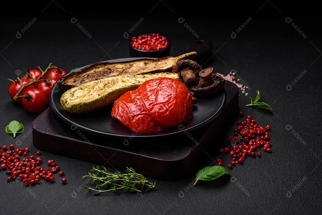Deliciosos legumes grelhados, abobrinha, berinjela, pimentão e cogumelos com sal, especiarias e ervas sobre um fundo escuro de concreto