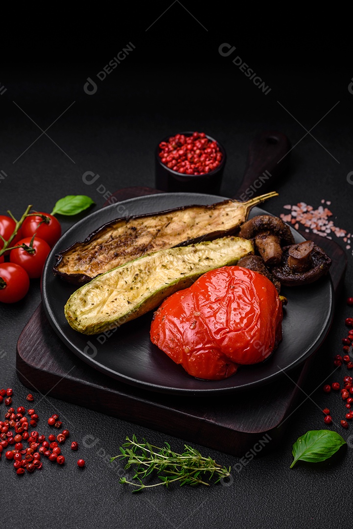 Delicioso suculento frango grelhado com sal, especiarias e ervas com legumes em um fundo escuro de concreto