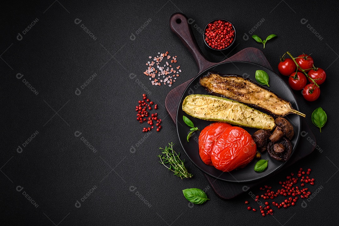 Deliciosos legumes grelhados, abobrinha, berinjela, pimentão e cogumelos com sal, especiarias e ervas sobre um fundo escuro de concreto