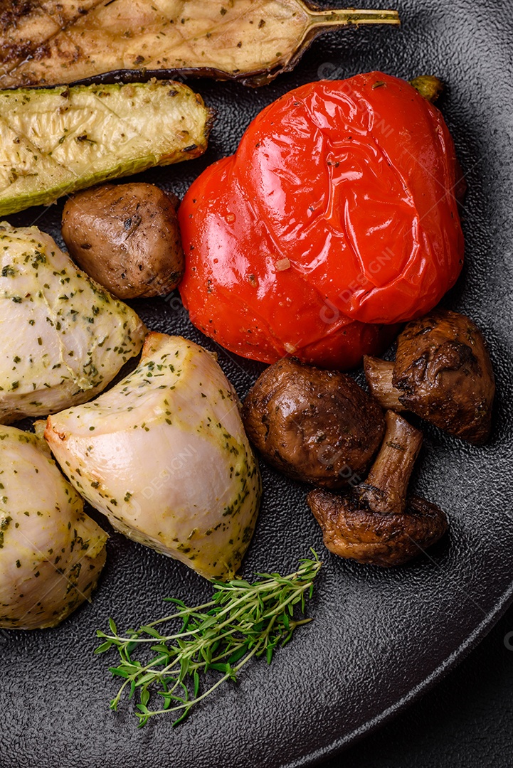 Deliciosos legumes grelhados, abobrinha, berinjela, pimentão e cogumelos com sal, especiarias e ervas sobre um fundo escuro de concreto