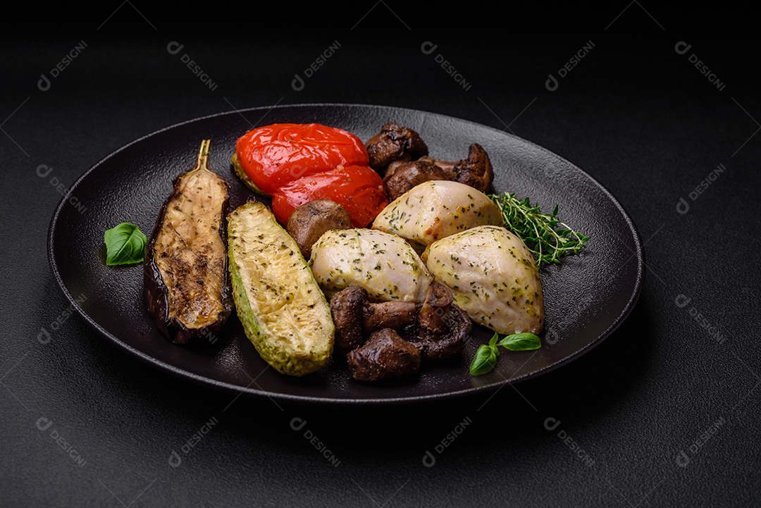 Delicioso suculento frango grelhado com sal, especiarias e ervas com legumes em um fundo escuro de concreto