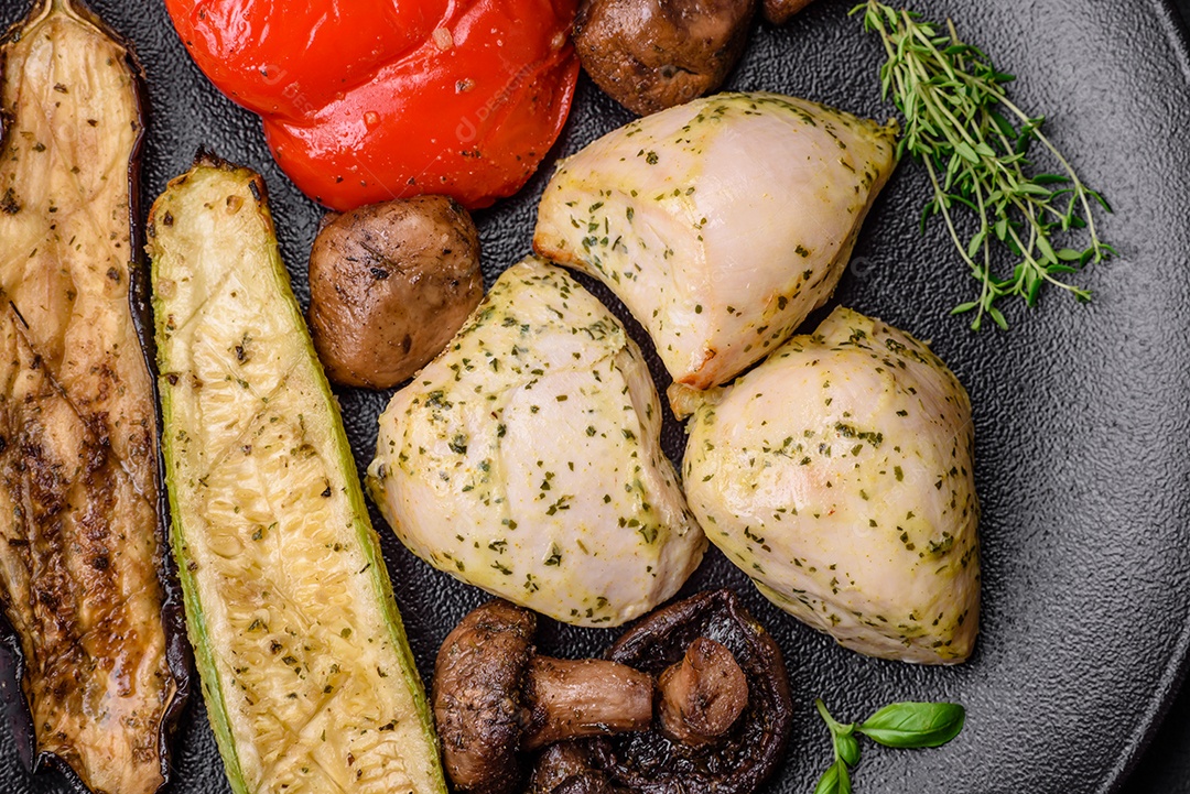 Deliciosos legumes grelhados, abobrinha, berinjela, pimentão e cogumelos com sal, especiarias e ervas sobre um fundo escuro de concreto