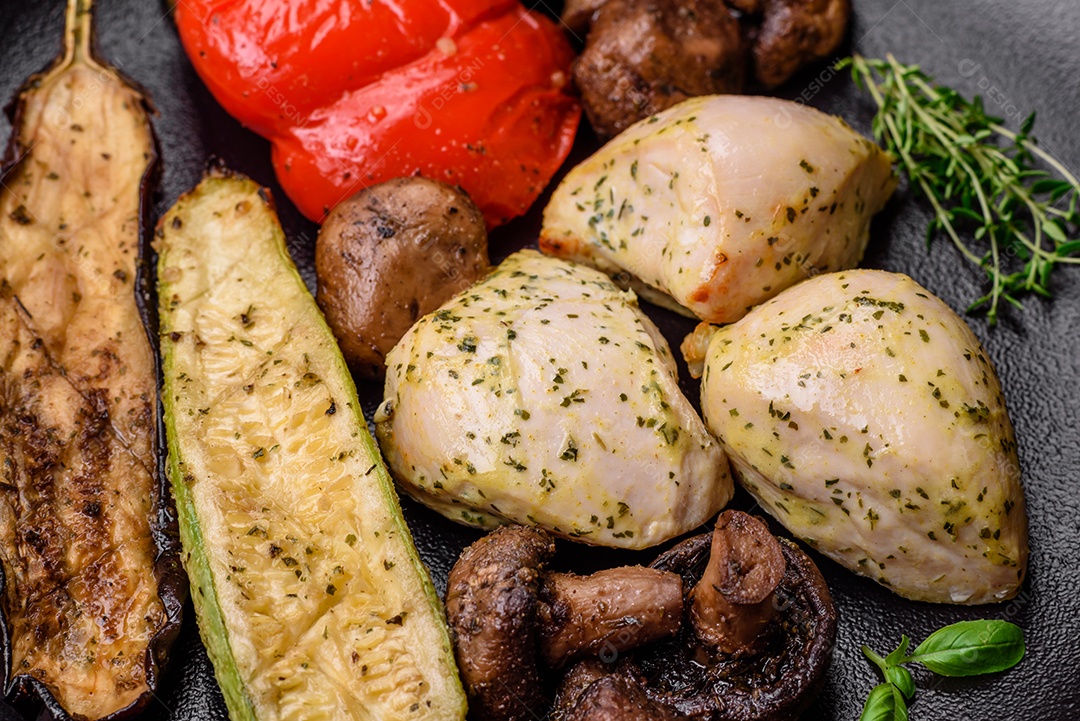 Deliciosos legumes grelhados, abobrinha, berinjela, pimentão e cogumelos com sal, especiarias e ervas sobre um fundo escuro de concreto