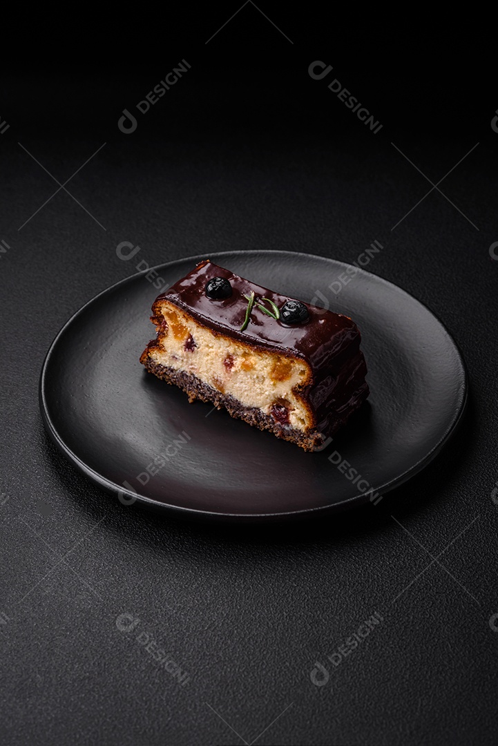 Delicioso cheesecake de sobremesa doce com frutas cristalizadas em chocolate sobre um fundo escuro de concreto