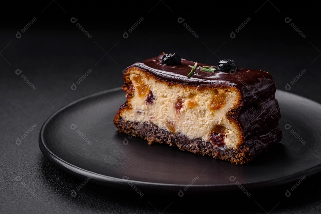 Delicioso cheesecake de sobremesa doce com frutas cristalizadas em chocolate sobre um fundo escuro de concreto