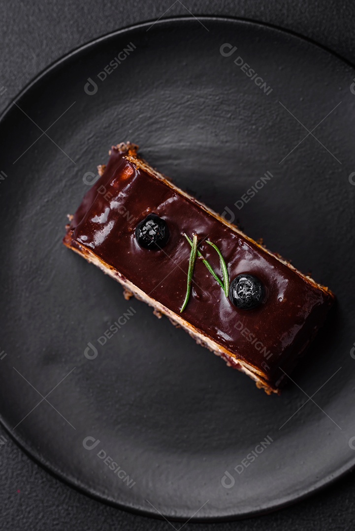 Delicioso cheesecake de sobremesa doce com frutas cristalizadas em chocolate sobre um fundo escuro de concreto