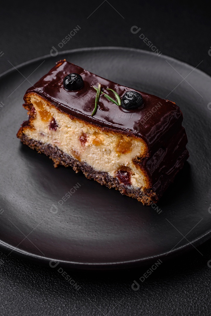Delicioso cheesecake de sobremesa doce com frutas cristalizadas em chocolate sobre um fundo escuro de concreto