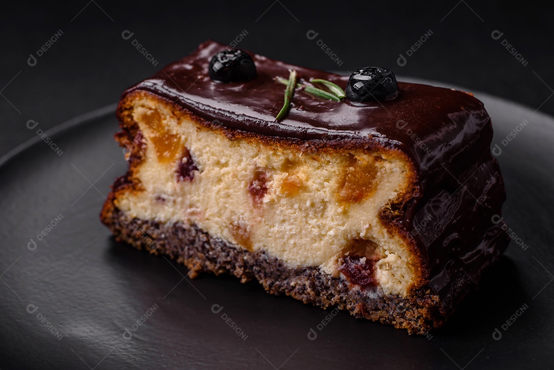 Delicioso cheesecake de sobremesa doce com frutas cristalizadas em chocolate sobre um fundo escuro de concreto