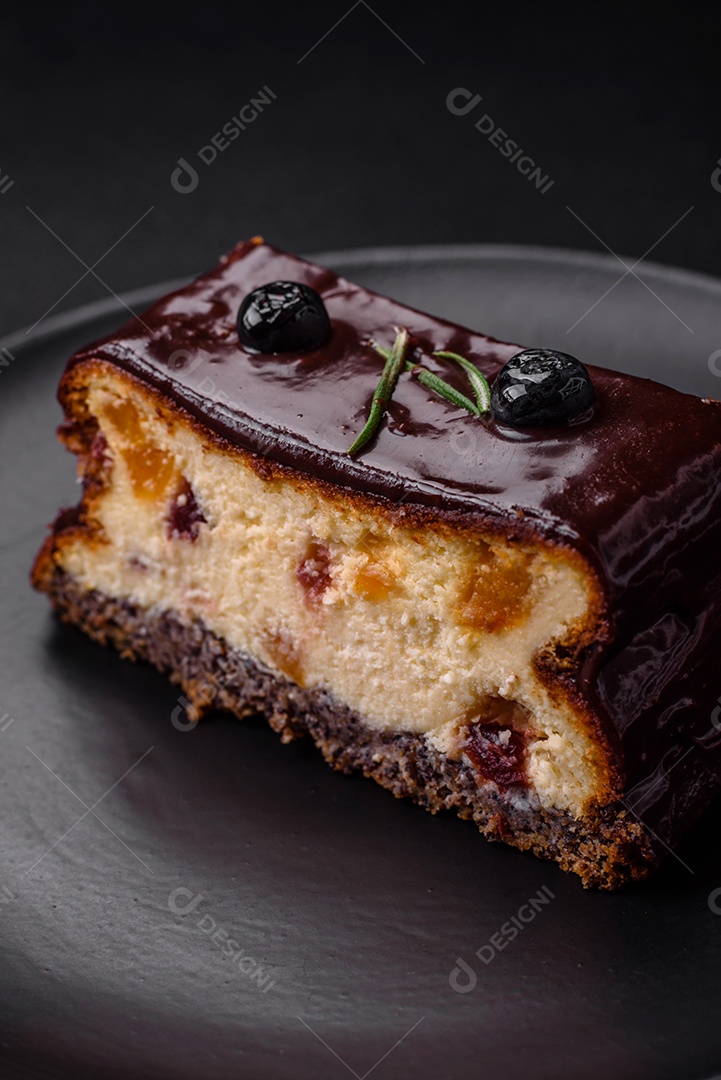 Delicioso cheesecake de sobremesa doce com frutas cristalizadas em chocolate sobre um fundo escuro de concreto