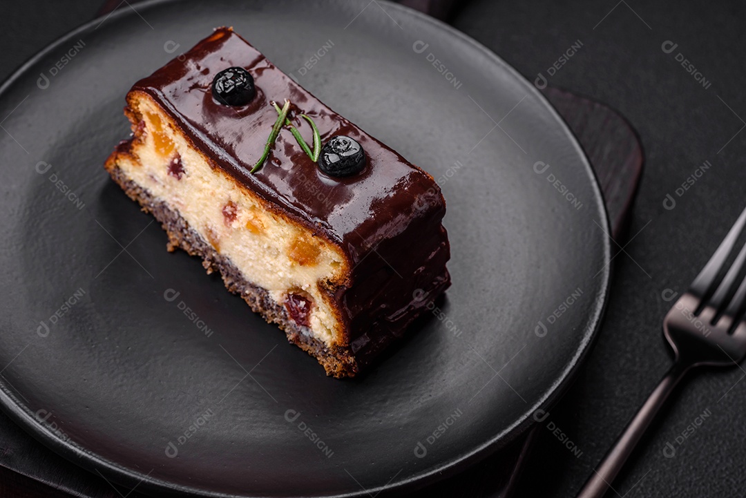 Delicioso cheesecake de sobremesa doce com frutas cristalizadas em chocolate sobre um fundo escuro de concreto