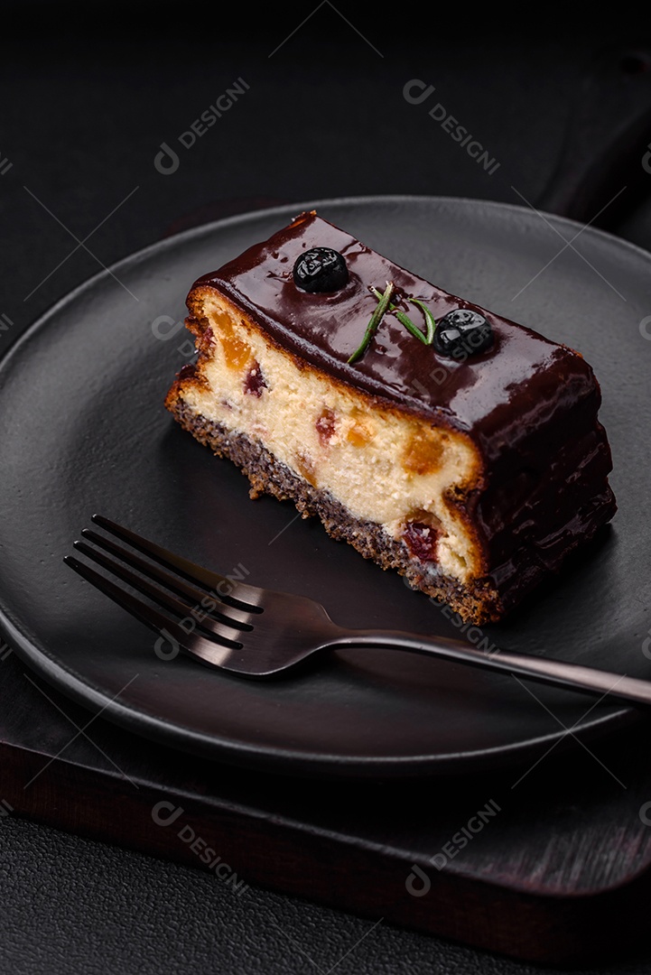 Delicioso cheesecake de sobremesa doce com frutas cristalizadas em chocolate sobre um fundo escuro de concreto