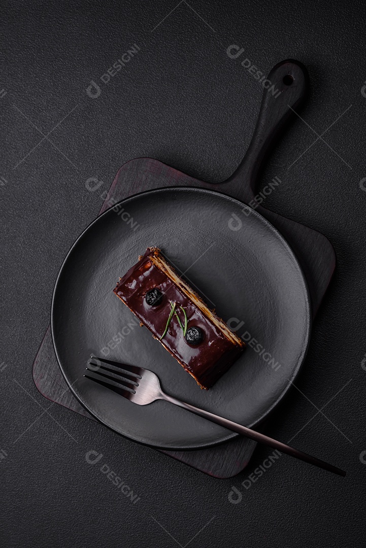 Delicioso cheesecake de sobremesa doce com frutas cristalizadas em chocolate sobre um fundo escuro de concreto