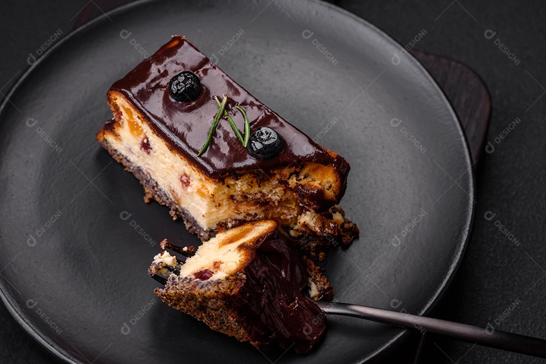 Delicioso cheesecake de sobremesa doce com frutas cristalizadas em chocolate sobre um fundo escuro de concreto