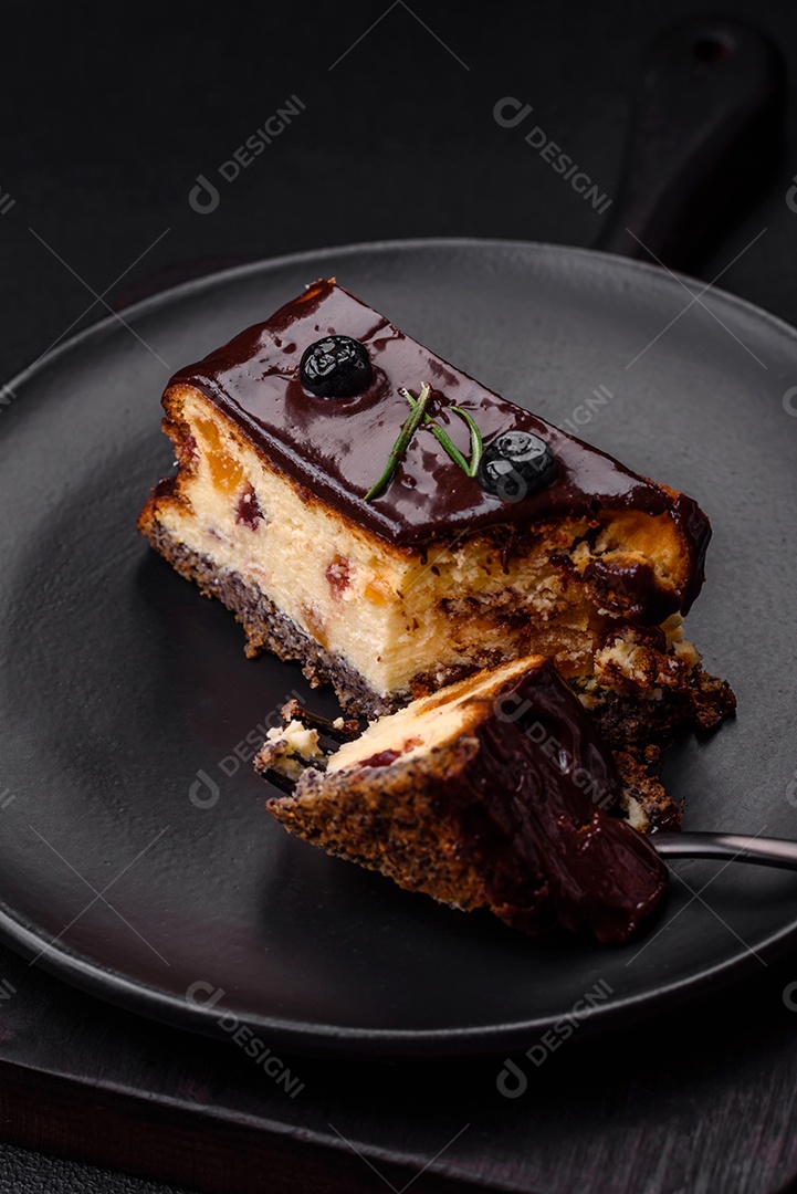 Delicioso cheesecake de sobremesa doce com frutas cristalizadas em chocolate sobre um fundo escuro de concreto