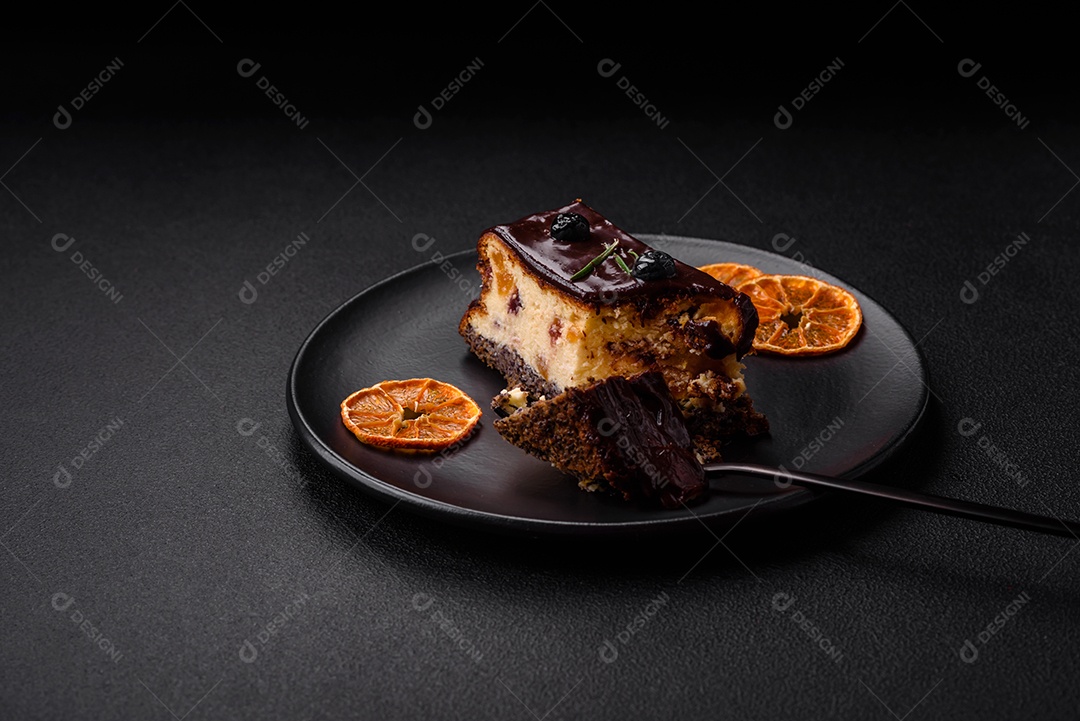Delicioso cheesecake de sobremesa doce com frutas cristalizadas em chocolate sobre um fundo escuro de concreto