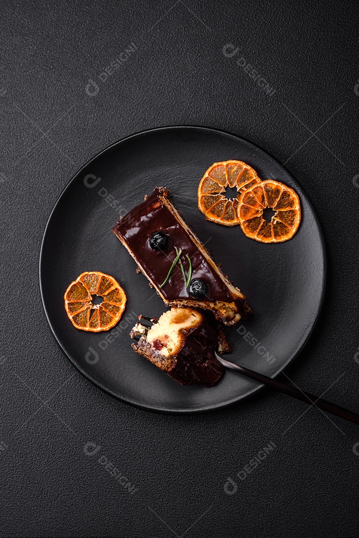 Delicioso cheesecake de sobremesa doce com frutas cristalizadas em chocolate sobre um fundo escuro de concreto