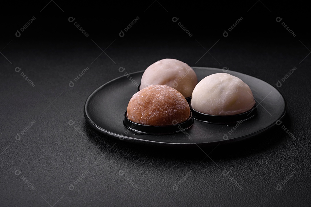 Deliciosa sobremesa mochi doce com coberturas em um fundo escuro de concreto. Sobremesa asiática vegetariana nutritiva
