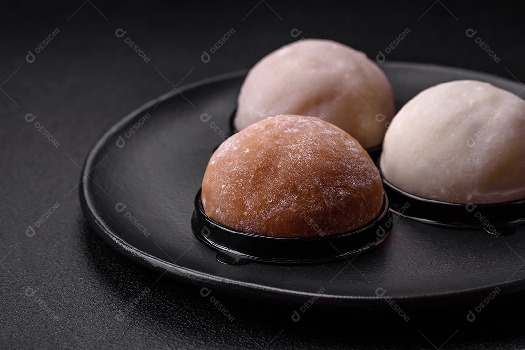 Deliciosa sobremesa mochi doce com coberturas em um fundo escuro de concreto. Sobremesa asiática vegetariana nutritiva