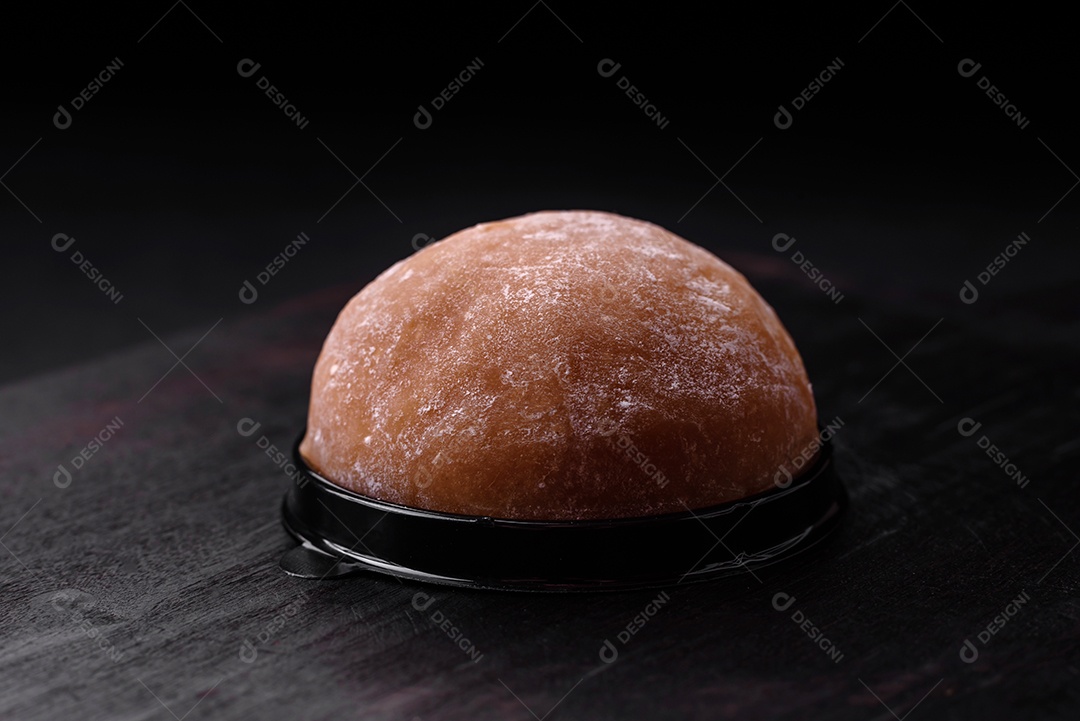 Deliciosa sobremesa mochi doce com coberturas em um fundo escuro de concreto. Sobremesa asiática vegetariana nutritiva