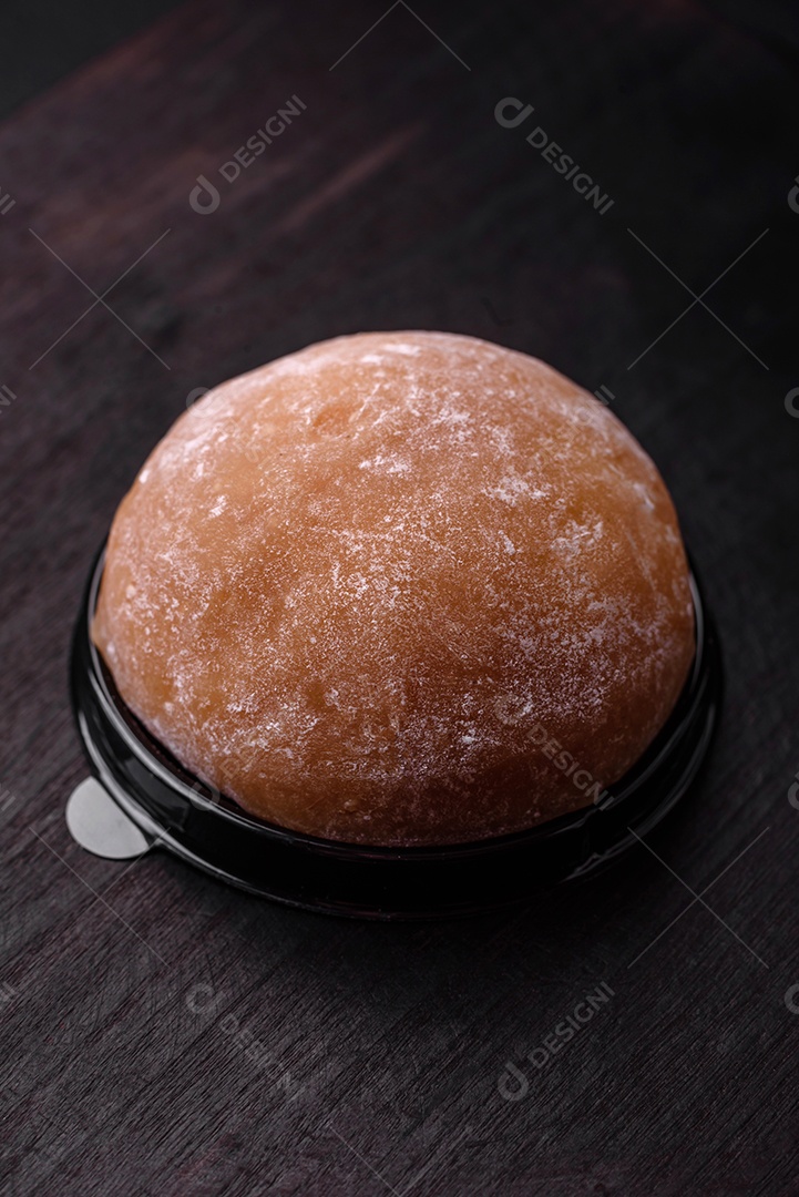 Deliciosa sobremesa mochi doce com coberturas em um fundo escuro de concreto. Sobremesa asiática vegetariana nutritiva