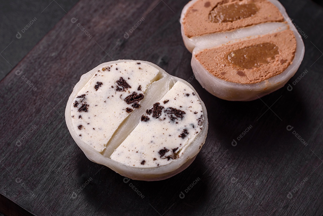 Deliciosa sobremesa mochi doce com coberturas em um fundo escuro de concreto. Sobremesa asiática vegetariana nutritiva