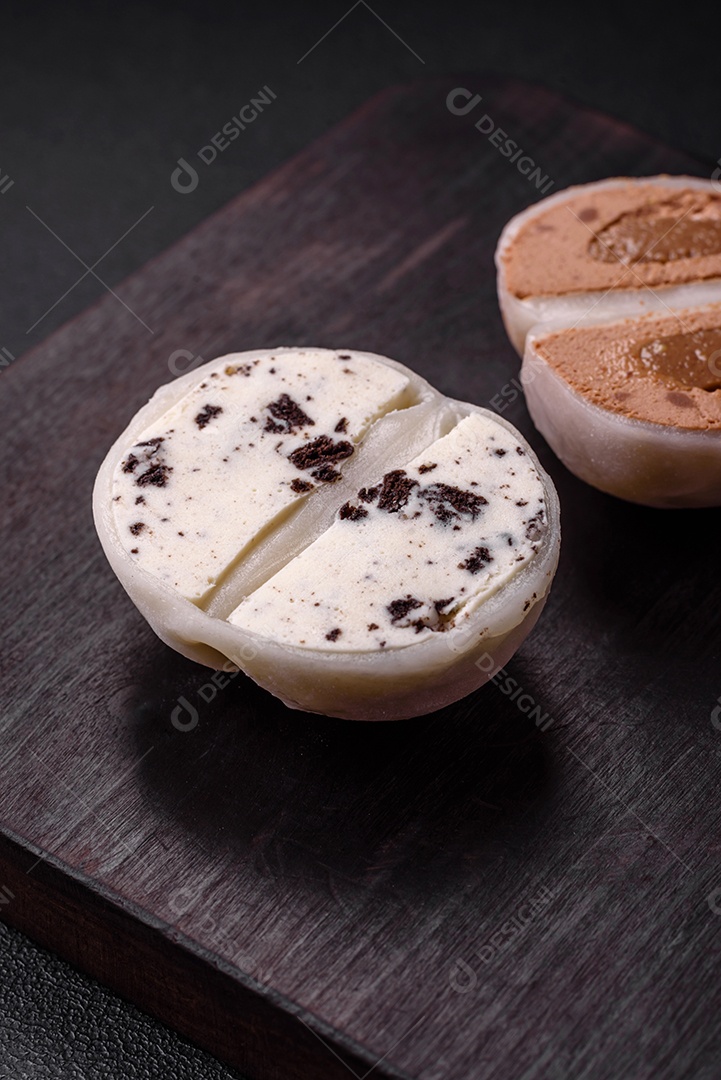 Deliciosa sobremesa mochi doce com coberturas em um fundo escuro de concreto. Sobremesa asiática vegetariana nutritiva