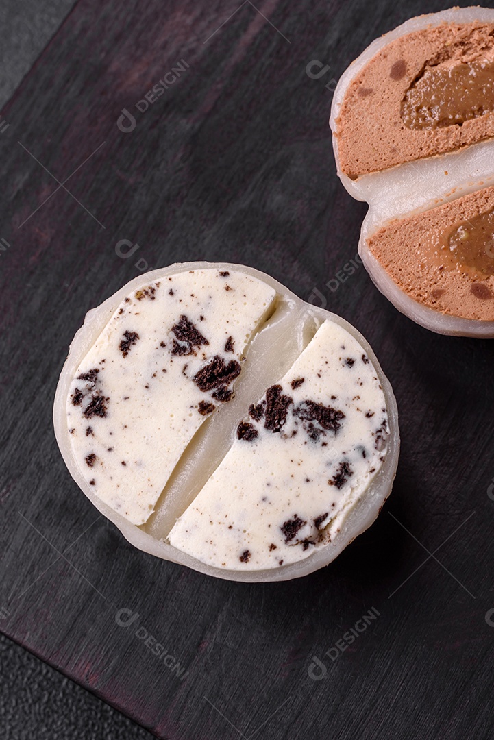 Deliciosa sobremesa mochi doce com coberturas em um fundo escuro de concreto. Sobremesa asiática vegetariana nutritiva