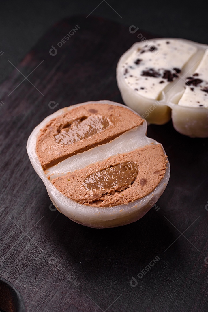 Deliciosa sobremesa mochi doce com coberturas em um fundo escuro de concreto. Sobremesa asiática vegetariana nutritiva
